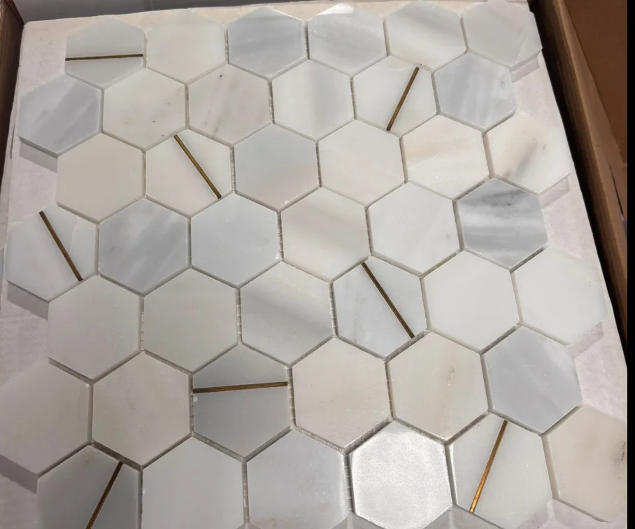 White hexagon tile sample with brass accent strips